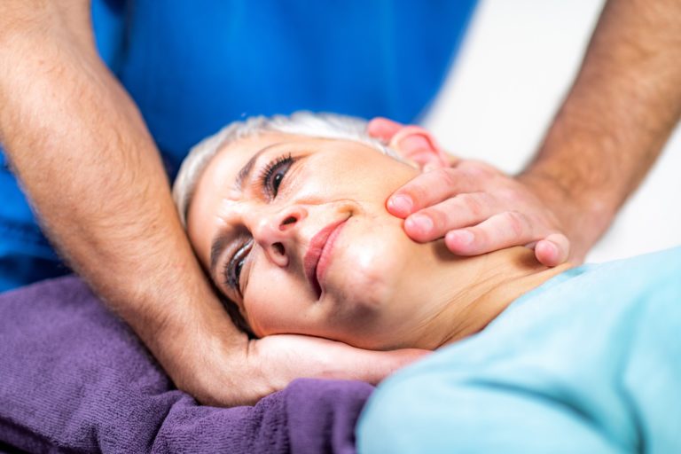 Physical Therapist Stretching Senior Woman’s Neck